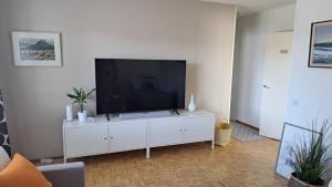 una sala de estar con una gran TV en un armario blanco en Santa's Arctic Residence, en Rovaniemi