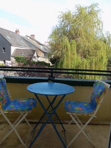 - Balcón con mesa azul y 2 sillas en STUDIO RDC au pied du château et balcon sur la vilaine, en Vitré