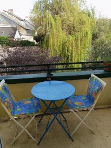 una mesa y dos sillas sentadas junto a una mesa en STUDIO RDC au pied du château et balcon sur la vilaine, en Vitré