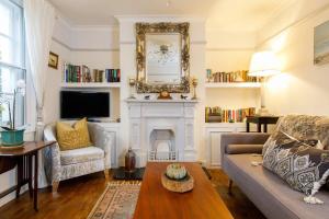 a living room with a couch and a fireplace at Beautiful Georgian Home in the heart of Chichester in Chichester