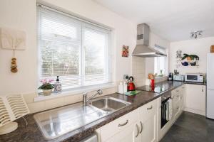 a kitchen with a sink and a large window at Beautiful Georgian Home in the heart of Chichester in Chichester