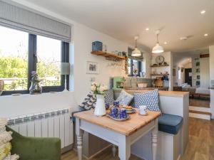 uma cozinha e sala de estar com uma mesa com flores em The Kiln House em Weymouth