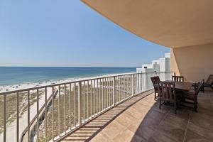 a balcony with a table and chairs and the beach at Luxury Gulf Front Condo Lazy River 704 in Orange Beach