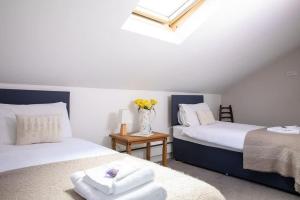 - une chambre avec 2 lits et un vase de fleurs sur une table dans l'établissement Lux Countryside Haven Mins to Beach Garden, à Birdham
