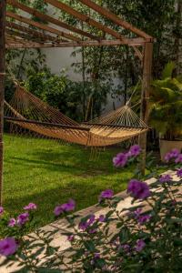 uma rede num jardim com flores roxas em Hotel Wellness - Belleza y Serenidad em Boca del Río