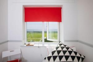 a red window with a red curtain in a room at Bright & modern Sussex seafront home Great views in Selsey