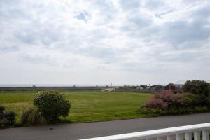 a view of a field of grass and a road at Bright & modern Sussex seafront home Great views in Selsey
