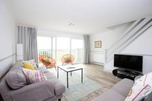 a living room with a couch and a tv at Bright & modern Sussex seafront home Great views in Selsey