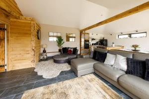 a living room with a couch and a table at Stylish Getaway Vast Courtyard Hot Tub in South Mundham