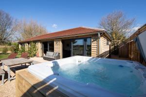 a large hot tub in front of a house at Stylish Getaway Vast Courtyard Hot Tub in South Mundham
