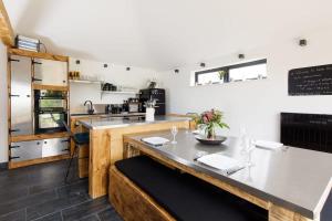 a kitchen with a counter with a table and a counter sidx sidx sidx at Stylish Getaway Vast Courtyard Hot Tub in South Mundham