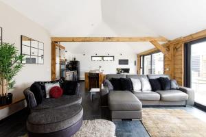 a living room with a couch and two chairs at Stylish Getaway Vast Courtyard Hot Tub in South Mundham +16 photos