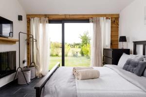 a bedroom with a large bed and a large window at Stylish Getaway Vast Courtyard Hot Tub 