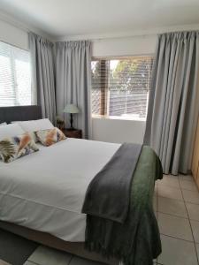 una camera da letto con un grande letto bianco e una finestra di @946 a Pretoria
