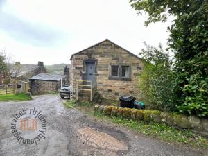 a small brick house with a door on a road at Walkers paradise on the Pennine way Charlestown in Halifax