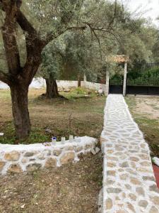 a stone path in a park with a tree at Helios Beach House in Mikros Gialos