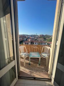 a patio with two chairs and a table on a balcony at A un passo dal mare! in Piombino