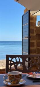 - une table avec une tasse de café sur une table donnant sur l'océan dans l'établissement Gioia di Mare, à Marzamemi