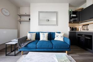 a blue couch in a living room with a table at Panoramic sea views in beachfront apt w balcony in Bognor Regis