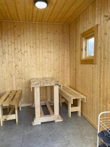 a wooden room with a picnic table and benches at Module house - Burabay in Borovoye