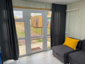 a living room with a couch and a sliding glass door at Module house - Burabay in Borovoye