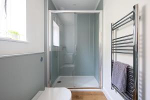 uma cabina de duche em vidro numa casa de banho com WC em Surfer's Paradise Steps to Beach Sleek&Stylish em East Wittering