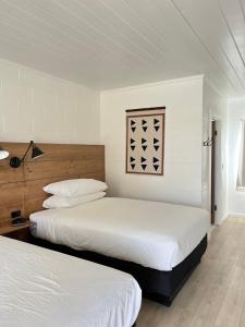 Duas camas num quarto com paredes brancas em Triangle Motel em Red Bluff