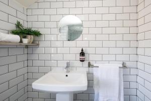 Baño blanco con lavabo y espejo en Rookwood - King Room in Gastro Pub, en West Wittering