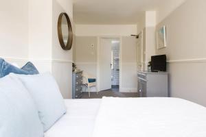 a white bedroom with a white bed and a desk at Rookwood - King Room in Gastro Pub in West Wittering
