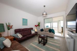 a living room with a couch and a table at Stunning Beachfront Apt w Balcony & Sea Views in Bognor Regis