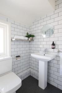 een witte badkamer met een wastafel en een toilet bij Rookwood - King Room in Gastro Pub in West Wittering