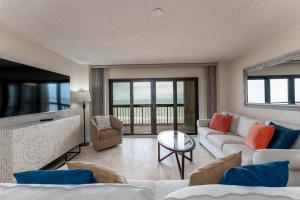 a living room with a couch and a table at Luxury, Direct Oceanfront Unit and Balcony, Southeast Corner, Heated Pool, Garage Parking in Ormond Beach