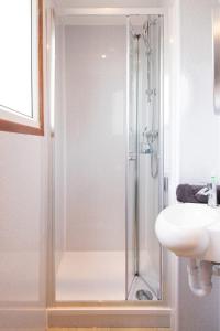 a shower with a glass door next to a sink at Stunning Beachfront Apt w Balcony & Sea Views in Bognor Regis