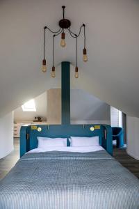 a bed with a blue head board in a room at The Salt House - Luxury Home with Pool & Hot Tub in Chichester