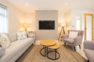 a living room with a couch and two chairs and a table at Designer Family Escape Hot Tub Steps to Beach in East Wittering