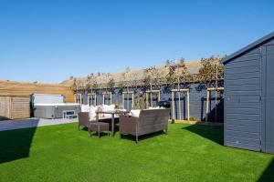 a backyard with a table and chairs on the grass at Designer Family Escape Hot Tub Steps to Beach in East Wittering