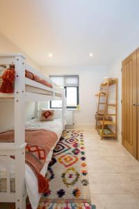 1 dormitorio con litera y alfombra en Designer Family Escape Hot Tub Steps to Beach, en East Wittering