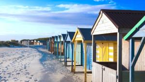 a row of colorful beach huts on the beach at Charming & Modern City Escape Garden Parking in Chichester