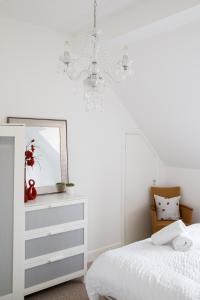 a bedroom with a white bed and a mirror at Lovely Selsey apartment with sea views sleeps 4 in Selsey