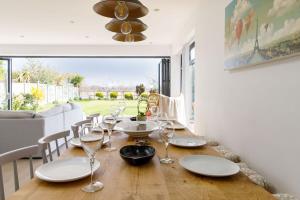 a dining room with a table with wine glasses at Designer Seaside Escape King Beds Scenic View in East Wittering