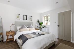 a bedroom with a large bed with two towels on it at Stylish Self-Contained Countryside Accommodation in Chichester