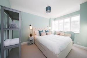 a bedroom with a large bed with pink and blue pillows at Designer Seaside Escape King Beds Scenic View in East Wittering