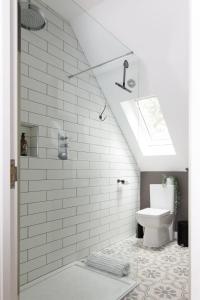 a white bathroom with a toilet and a skylight at Stylish Self-Contained Countryside Accommodation in Chichester