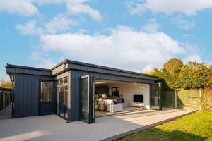 a black container house with a deck at Designer Seaside Escape King Beds Scenic View in East Wittering
