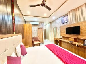 a hotel room with a bed and a flat screen tv at HOTEL SIDDHANT PALACE ! VARANASI fully-Air-Conditioned hotel at prime location, Lift-&-wifi-available, near-Kashi-Vishwanath-Temple, and-Ganga-ghat in Varanasi