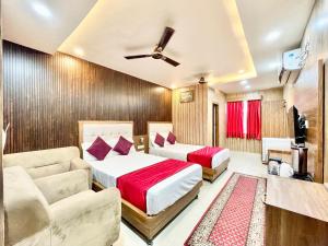 バラナシにあるHOTEL SIDDHANT PALACE ! VARANASI fully-Air-Conditioned hotel at prime location, Lift-&-wifi-available, near-Kashi-Vishwanath-Temple, and-Ganga-ghatのベッドルーム1室(ベッド2台、ソファ付)