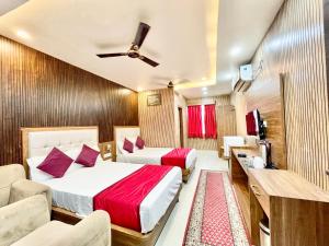 a hotel room with two beds and a couch at HOTEL SIDDHANT PALACE ! VARANASI fully-Air-Conditioned hotel at prime location, Lift-&-wifi-available, near-Kashi-Vishwanath-Temple, and-Ganga-ghat in Varanasi
