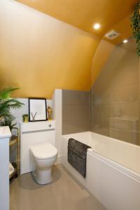 uma casa de banho com um WC, uma banheira e um lavatório. em Luxury Penthouse ~ Super King Bed 5 min to Beach em East Wittering
