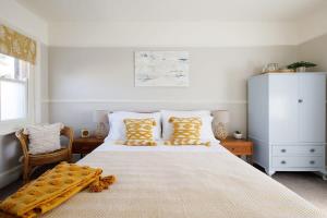 a bedroom with a large bed with yellow pillows at Stocker - King Room in Gastro Pub in West Wittering