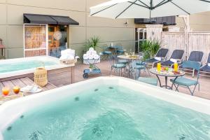 a hot tub on a deck with chairs and tables at Lennox Buenos Aires in Buenos Aires
